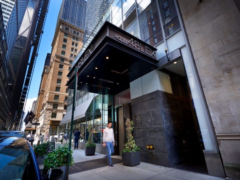 Hotel 48LEX New York entrance with modern architecture, street view, and pedestrian.