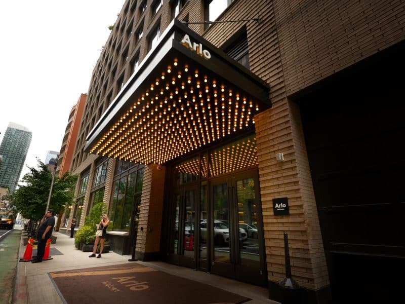 Arlo Midtown hotel entrance featuring modern design, illuminated awning, and welcoming atmosphere in Manhattan.
