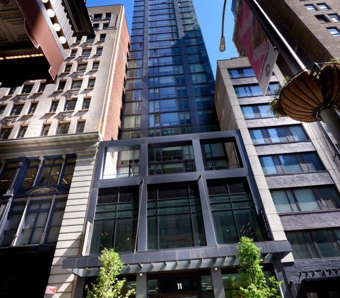 Modern Arlo NoMad hotel exterior in Manhattan's NoMad neighborhood, showcasing sleek glass design and surrounding historic buildings.