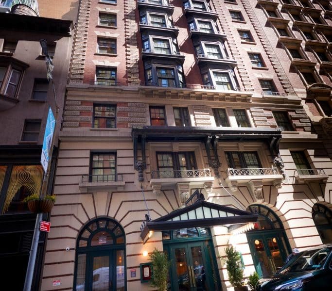 The Evelyn Hotel exterior showcasing Gilded Age architecture, located in Manhattan’s NoMad neighborhood, with detailed brickwork and welcoming entrance.