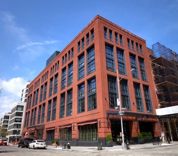 Fouquet’s New York boutique hotel exterior, showcasing red brick architecture and large windows in the stylish Tribeca neighborhood of Manhattan.