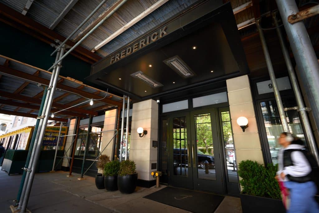 Frederick Hotel entrance with modern design, greenery, and scaffolding in Tribeca, Manhattan, highlighting boutique accommodation features.