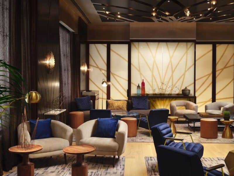 Stylish hotel lounge area at Hyatt Centric Wall Street featuring modern seating, decorative lighting, and elegant decor, ideal for relaxation and business meetings.
