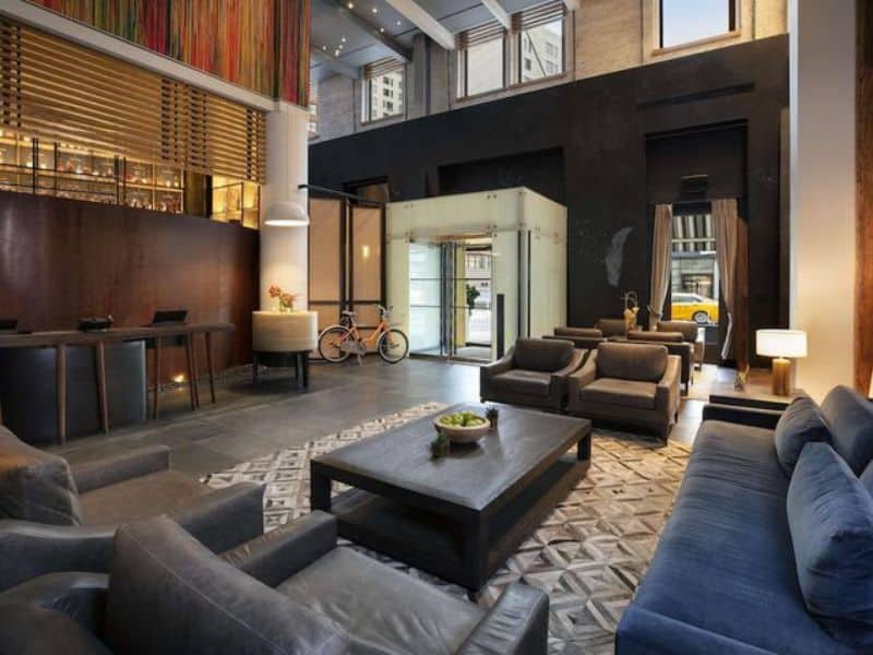 Stylish lobby of Hyatt Union Square New York featuring modern seating, a reception desk, and a bicycle, highlighting the hotel's boutique design and urban amenities.