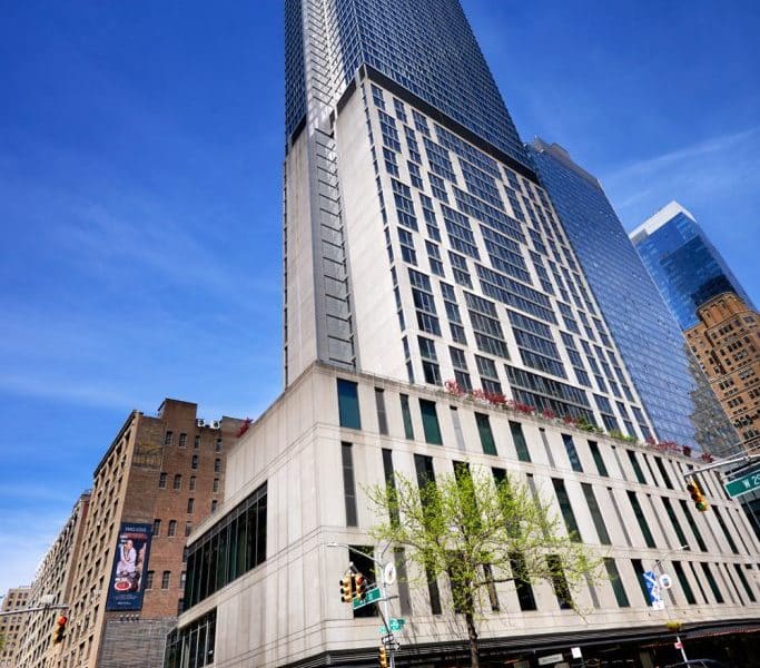Kimpton Hotel Eventi exterior view showcasing modern architecture, located in Chelsea, New York City, with a clear blue sky and surrounding urban landscape.