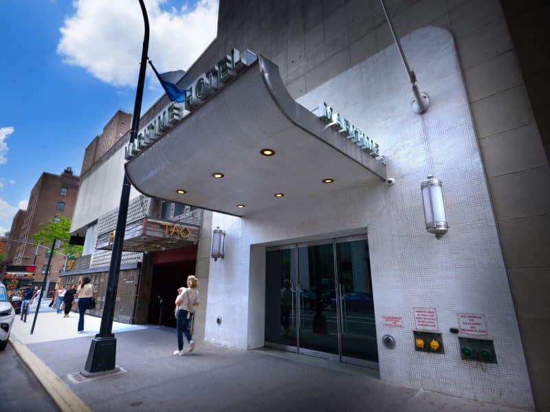 The Maritime Hotel entrance with nautical-inspired design, featuring a prominent sign, modern lighting, and nearby pedestrians in Manhattan's Chelsea neighborhood.