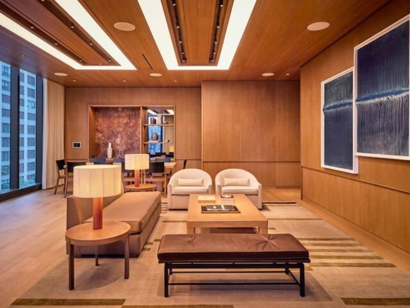 Luxury hotel lobby at Pendry Manhattan West featuring contemporary design, wooden accents, modern furniture, and large windows.