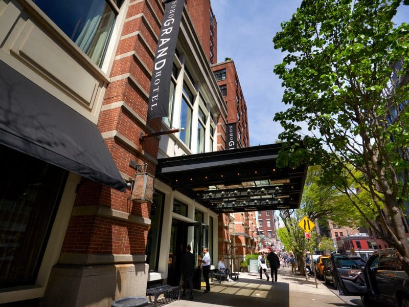 Soho Grand Hotel entrance with stylish façade, welcoming atmosphere, and outdoor seating in Manhattan's SoHo neighborhood.