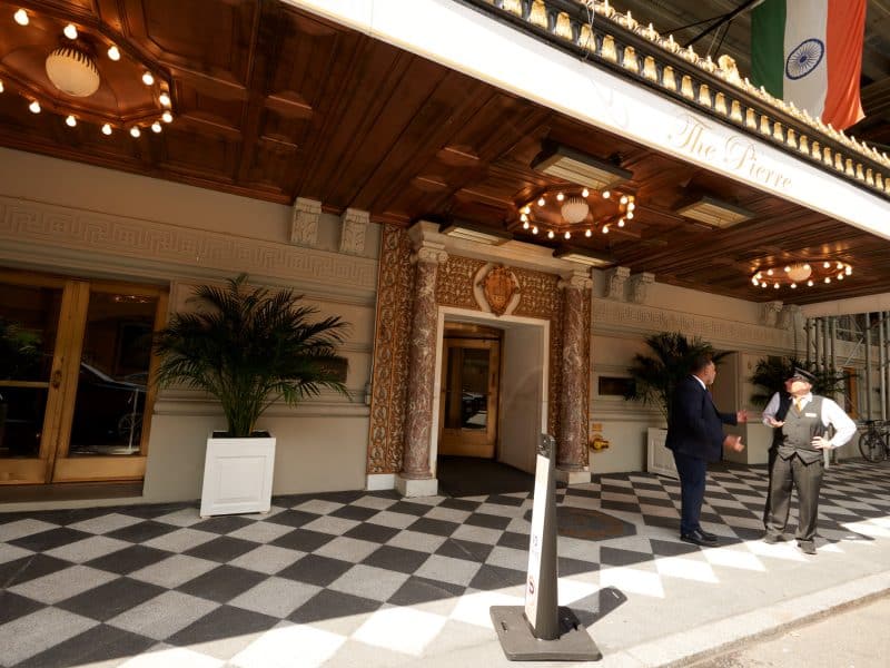 The Pierre hotel entrance with elegant decor, checkered flooring, and staff welcoming guests.
