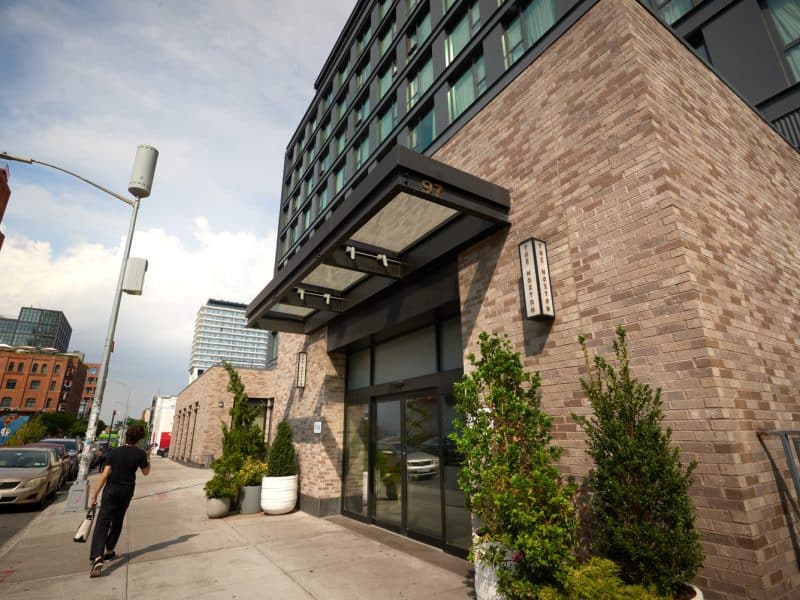 The Hoxton, Williamsburg boutique hotel entrance showcasing modern design, industrial brick exterior, and greenery, located in Brooklyn's vibrant Williamsburg neighborhood.