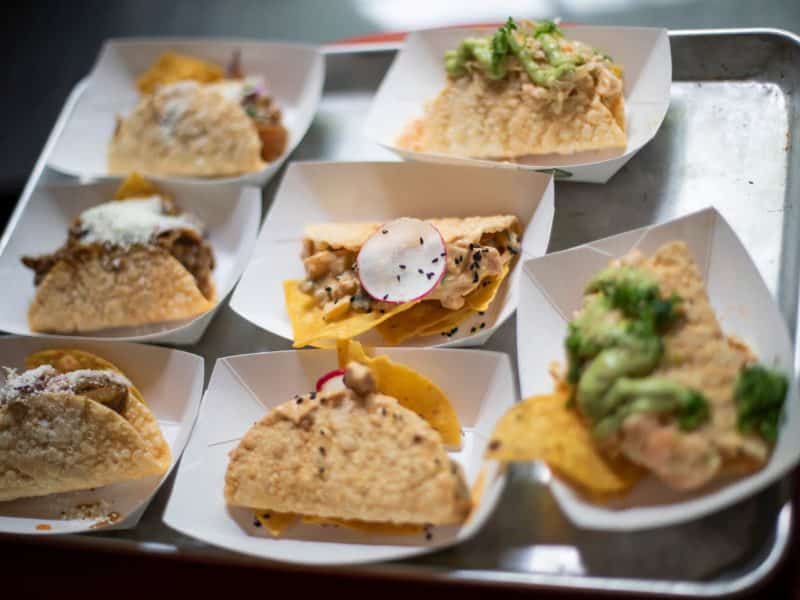 Assorted gourmet tacos served on a tray, featuring various toppings and fillings, representing the culinary delights available on the Chelsea Market, Meatpacking, and High Line Food Tour in NYC.