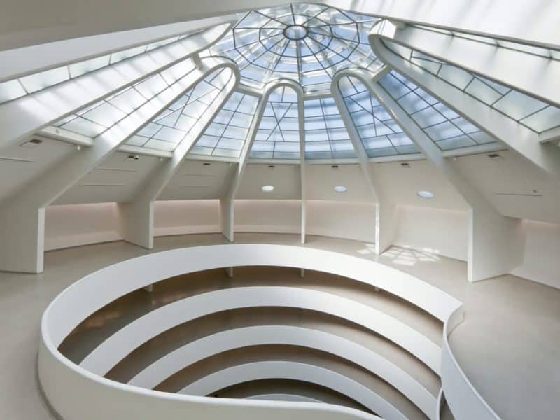 Interior view of the Solomon R. Guggenheim Museum showcasing the iconic spiral ramp and skylight, highlighting Frank Lloyd Wright's architectural design and modern art space.