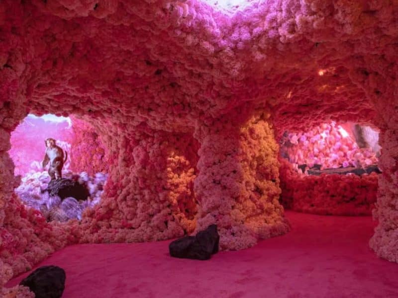 Interior of Mercer Labs Museum of Art and Technology featuring immersive pink floral installations and a central figure, part of the "Maestros and the Machines" exhibit.