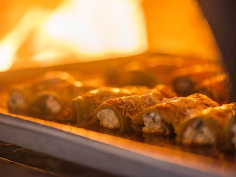 Baked stuffed peppers with melted cheese, showcasing a delicious culinary experience from the Original Greenwich Village Food & Culture Walking Tour.