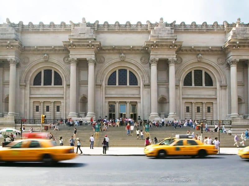 Metropolitan Museum of Art entrance with visitors and yellow taxis, highlighting the guided tour experience and skip-the-line entry.