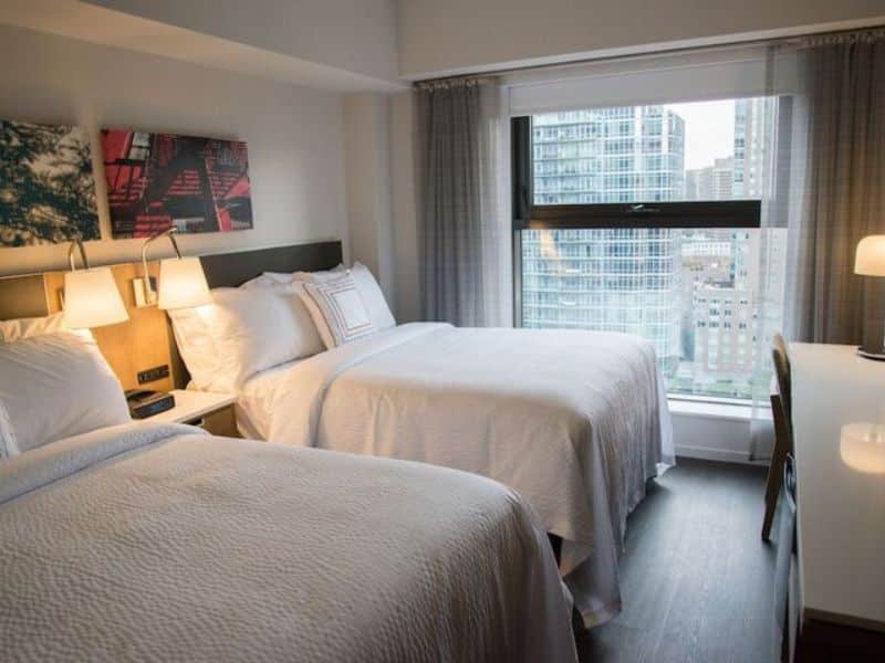 Cozy hotel room at Fairfield Inn & Suites by Marriott New York Manhattan/Central Park with two beds, city views, and modern decor.