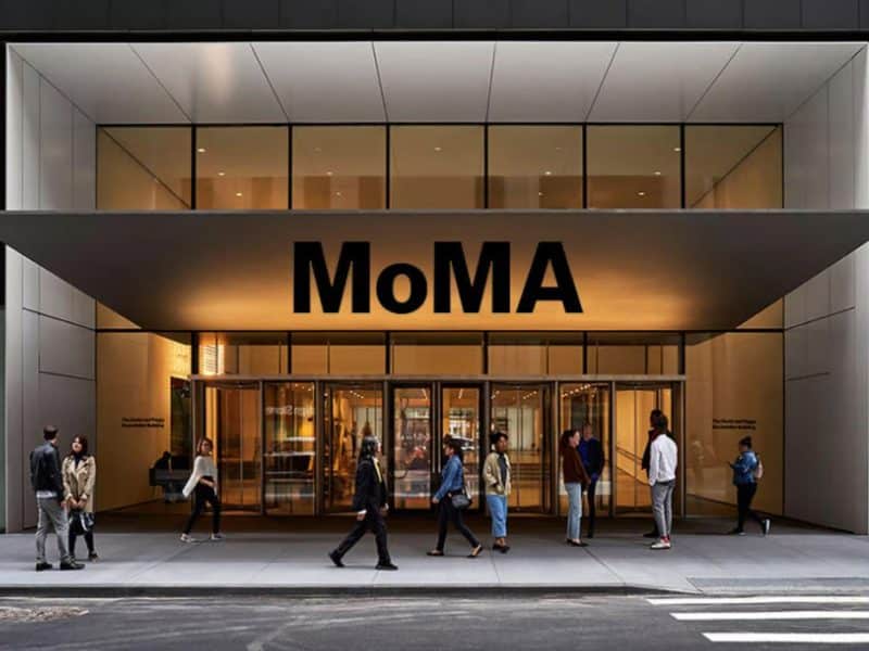 MoMA entrance in Midtown Manhattan with visitors, showcasing modern architecture and vibrant urban atmosphere.