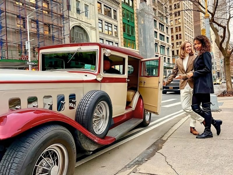 Couple enjoying a moment by a classic vintage car on a city street, highlighting the Vintage Wine Tasting and Classic Car Combo Tour experience.
