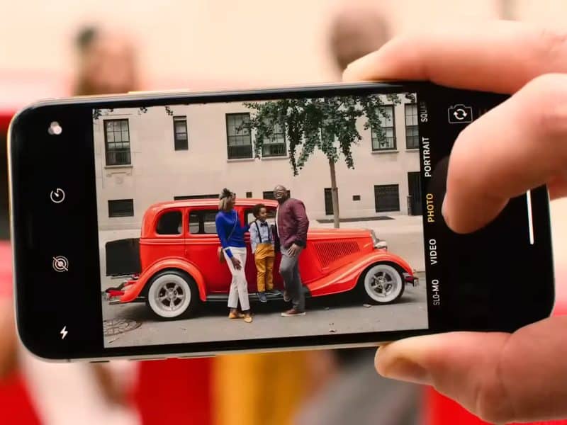 Group of people posing with a vintage red car, capturing a joyful moment during the Vintage Wine Tasting and Classic Car Combo Tour in New York City.