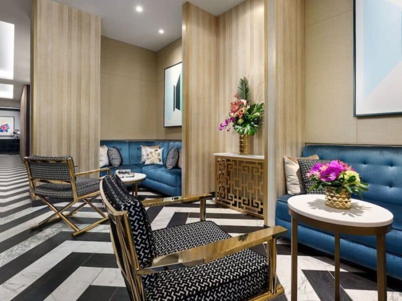 Modern lounge area at Hotel 57 featuring blue sofas, stylish chairs, decorative flowers, and contemporary artwork, emphasizing comfort and elegance in Midtown Manhattan.