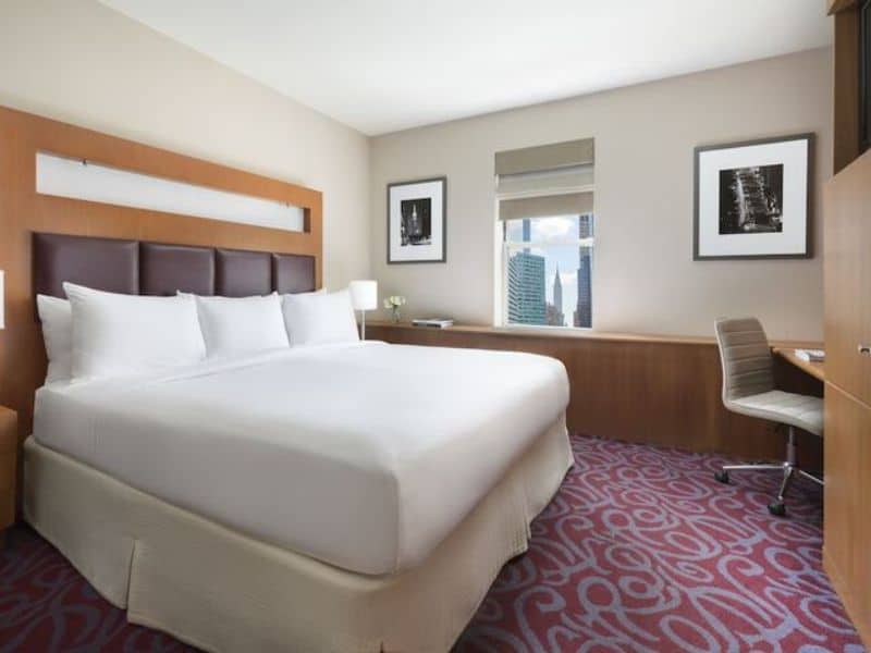 Modern hotel room at Hotel 57 in Midtown Manhattan, featuring a queen bed, desk, and city view, highlighting comfort and convenience for travelers.
