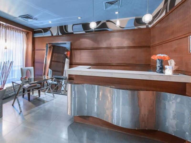 Modern hotel lobby with sleek reception desk, stylish furniture, and natural light, showcasing the Moderne Hotel's contemporary design and welcoming atmosphere in Midtown Manhattan.