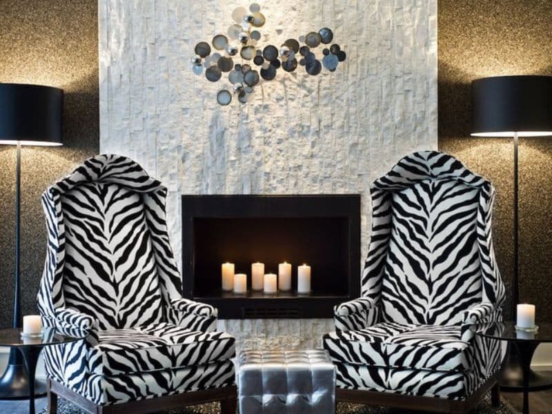 Zebra-patterned armchairs in a stylish hotel lobby with a modern fireplace and decorative wall art, reflecting the chic ambiance of Moderne Hotel in New York City.
