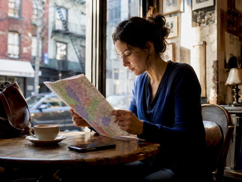 Traveler studying NYC hotel zones map at café